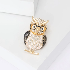 Close-up of owl brooch with sparkling rhinestones and black and white enamel details