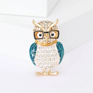 Macro shot of owl brooch featuring blue enamel wings and sparkling inlaid rhinestones