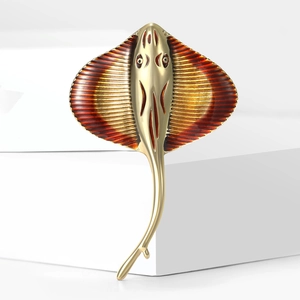 Detailed close-up of a golden stingray brooch with red gradient enamel and rib texture