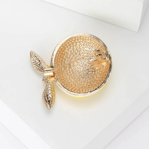 Back view of a gold lemon brooch with yellow enamel detail and secure pin fastening
