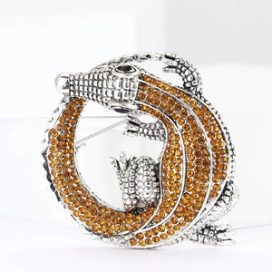 Detailed close-up of a silver-plated crocodile brooch with amber crystals and black gem eyes