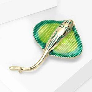 Macro shot of gold-plated alloy stingray brooch with green and yellow enamel details