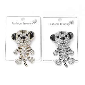 Close-up of diamond-studded tiger brooches with black enamel detail in gold and silver finish