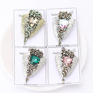 Macro detail of vintage triangle crystal brooches in four colors on silver alloy bases