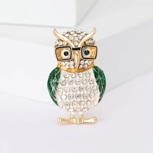 Detail view of owl brooch with green enamel wings and white rhinestones on alloy