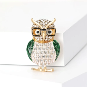 Detailed owl brooch with sparkling rhinestones, yellow eyes and green enamel wings