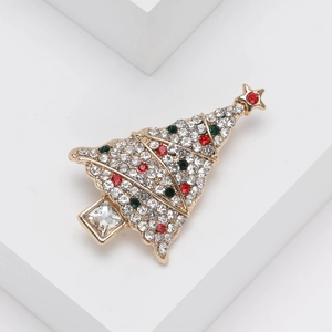 Détail macro de broche sapin de Noël avec strass colorés sur monture dorée