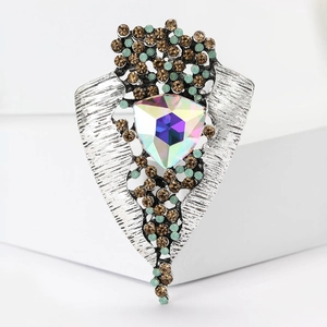 Macro detail of vintage alloy brooch featuring a large triangle AB crystal and rhinestones