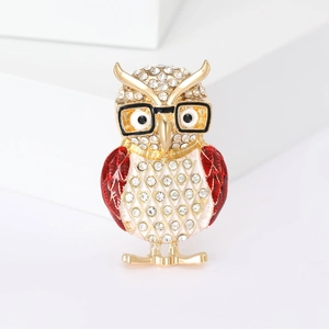 Detail of owl brooch with gold plating, clear rhinestones, and red enamel wings