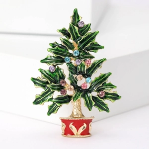 Detailed view of enamel Christmas tree brooch with colorful rhinestones on white display