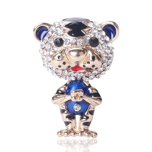 Detail of cute tiger brooch in gold metal with white rhinestones and blue enamel inlay
