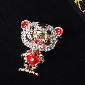 Close-up of tiger brooch with gold metal plating, white rhinestones and red enamel details
