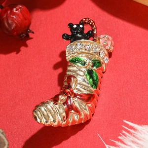 Vintage gold alloy Christmas stocking brooch with black bear and green holly leaf accents