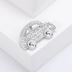 Elegante spilla per auto argentata con strass scintillanti su sfondo bianco minimalista