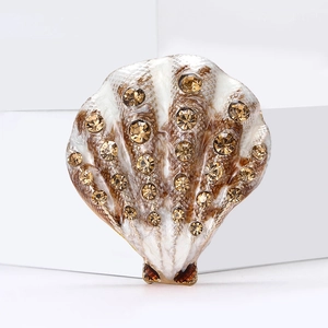 Detail of shell brooch with enamel texture and champagne rhinestones on white steps