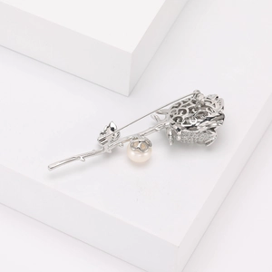 Détail de la broche rose argentée avec pétales en zircon et perle ronde élégante