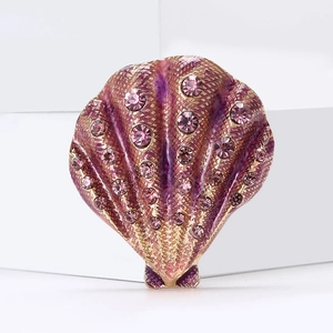 Detail of shell brooch with purple enamel finish and small pink rhinestones on gold base