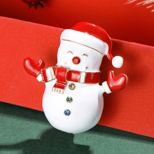 Broche bonhomme de neige en émail avec strass sur un fond festif rouge et vert élégant