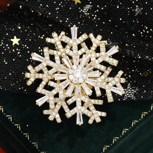 Elegant gold plated snowflake brooch with sparkling cubic zirconia on green velvet box