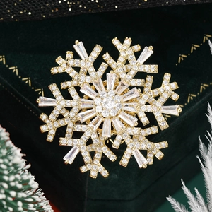 Macro shot of rotating gold snowflake brooch with sparkling zircon on green velvet