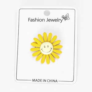Macro detail van zonnebloem broche met smiley op witte display kaart
