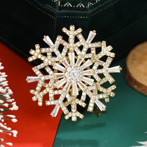 Detailed macro view of rotating gold snowflake brooch with sparkling cubic zirconia