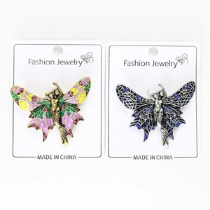 Close-up of artistic angel brooches in gold and silver finish with colorful enamel details
