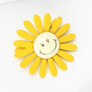 Minimalistische zonnebloem broche met gele bloemblaadjes en een blij gezichtje
