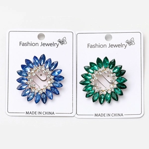 Vue macro détaillée des broches à fleurs en strass bleu marine et vert émeraude