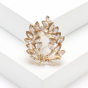 Elegant gold laurel branch brooch with champagne crystals and sparkling diamond bow accent