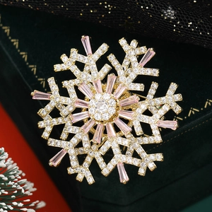 Detail of a rotating double-layer snowflake brooch with pink zircon and gold plating