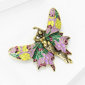 Detailed macro view of vintage angel brooch with purple enamel and pink crystals