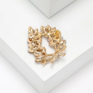 Macro-opname van de achterkant van een gouden broche met een veiligheidsspeldsluiting