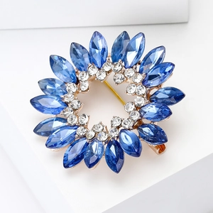 Détail d'une broche fleur en cristal bleu roi avec plaquage or et épingle de sûreté