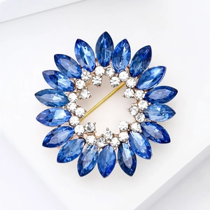 Vue détaillée d'une broche fleurie bleue sertie de strass sur monture dorée