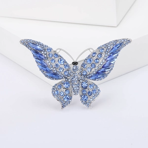 Detailopname van de blauwe kristallen en het zilveren metalen frame van de vlinderbroche