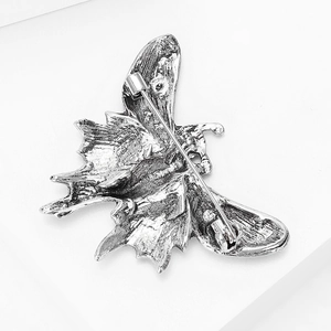 Detailed back view of silver butterfly brooch showing secure safety pin clasp and texture