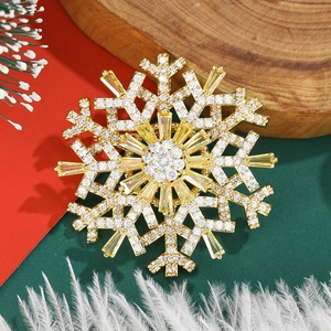 Detailed close-up of a double-layered golden snowflake brooch with sparkling zircons