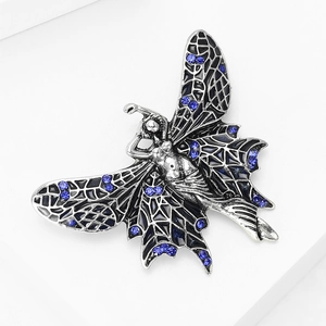 Macro detail of a vintage silver angel brooch with black enamel and blue rhinestones
