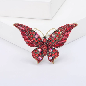 Detailopname van luxe retro vlinderbroche met rode strassteenen en aurora stenen