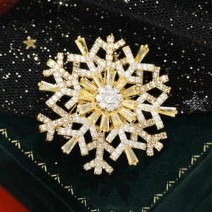 Luxurious snowflake brooch with sparkling cubic zirconia on a gold base for women