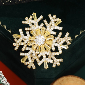 Close-up of rotatable snowflake brooch with sparkling gold-tone metal and cubic zirconia