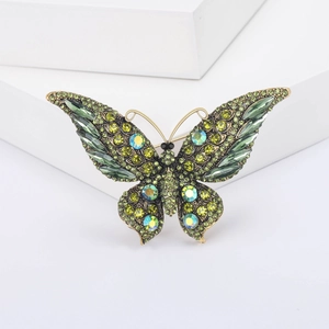 Vintage vlinderbroche met groene kristallen in antiek goud voor elegante mode stijl