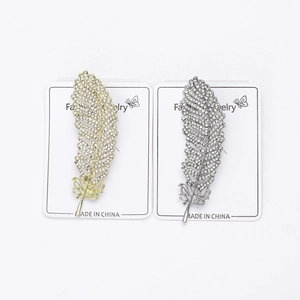 Detail of silver and gold feather brooches with intricate rhinestone inlay craftsmanship