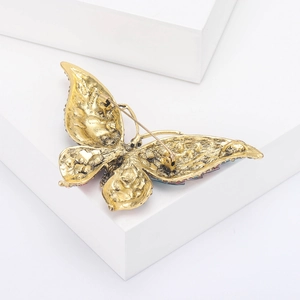 Detailaanzicht van de achterkant van een vlinderbroche met een gouden veiligheidsspeld