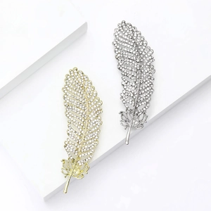 Elegant gold and silver feather leaf brooches with sparkling crystal rhinestones set on white cubes
