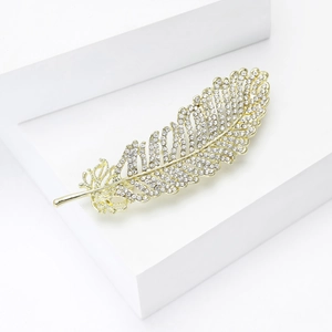 Close-up of elegant gold leaf brooch with sparkling crystals and fine craftsmanship