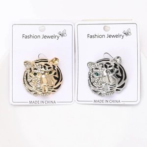 Detailed close-up of tiger head brooches with crystal rhinestones on white gift card