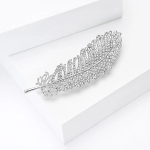 Macro detail of elegant silver leaf brooch featuring densely set sparkling white rhinestones