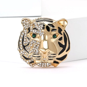 Vintage tiger head brooch with rhinestones and green eyes on a white pedestal
